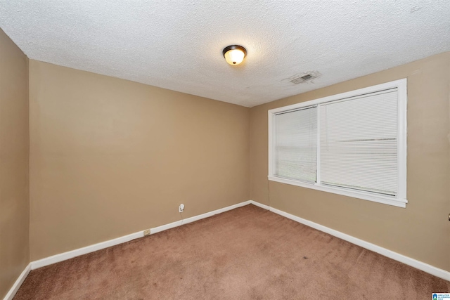 carpeted empty room featuring a textured ceiling