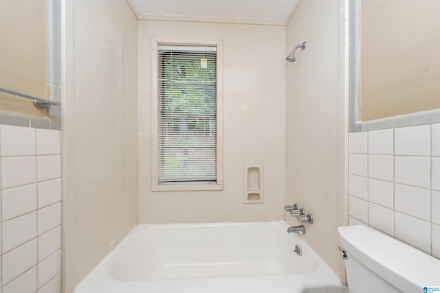 bathroom with toilet, tile walls, and  shower combination