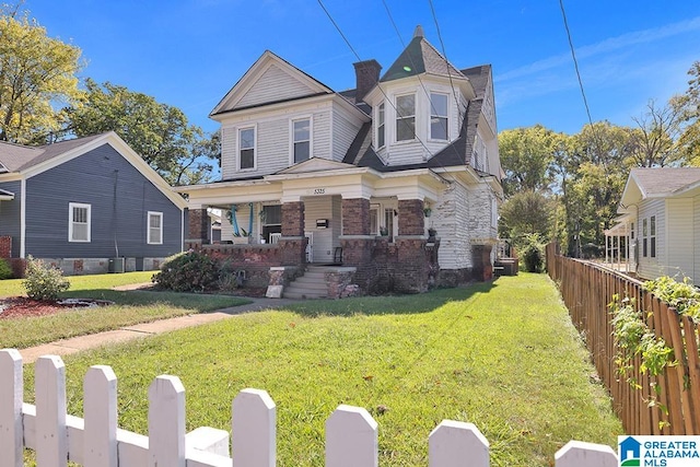 view of front of house featuring covered porch and a front yard