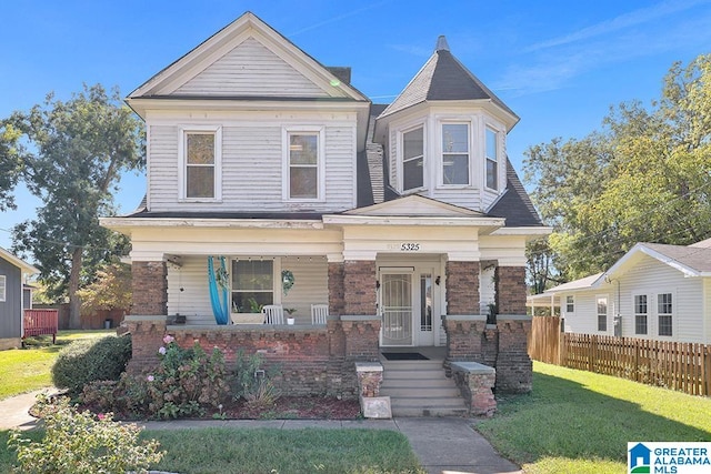 view of front facade with a front lawn and covered porch