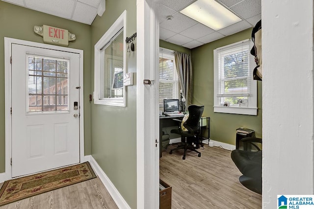 home office featuring light hardwood / wood-style floors, a paneled ceiling, and a healthy amount of sunlight