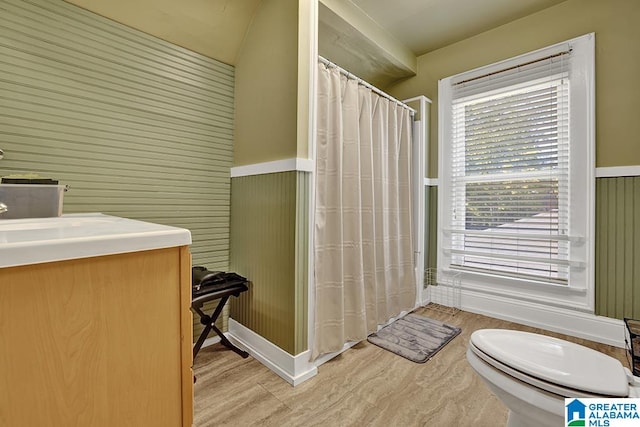 bathroom with hardwood / wood-style floors, toilet, a shower with curtain, wooden walls, and vanity