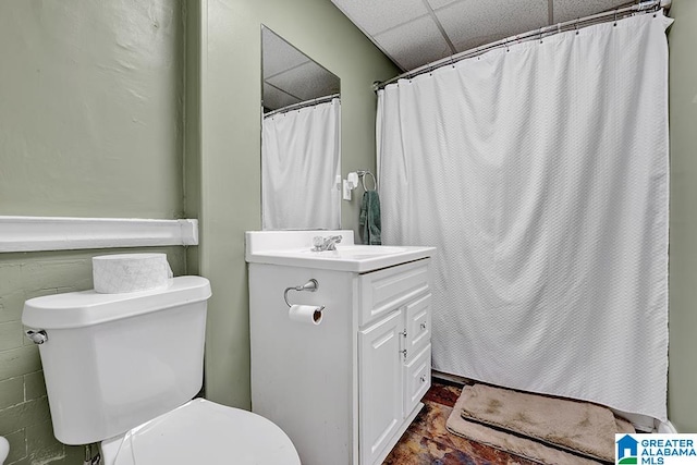 bathroom with vanity, a drop ceiling, and toilet