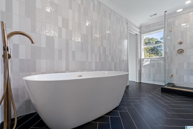 bathroom featuring tile patterned floors, plus walk in shower, and tile walls