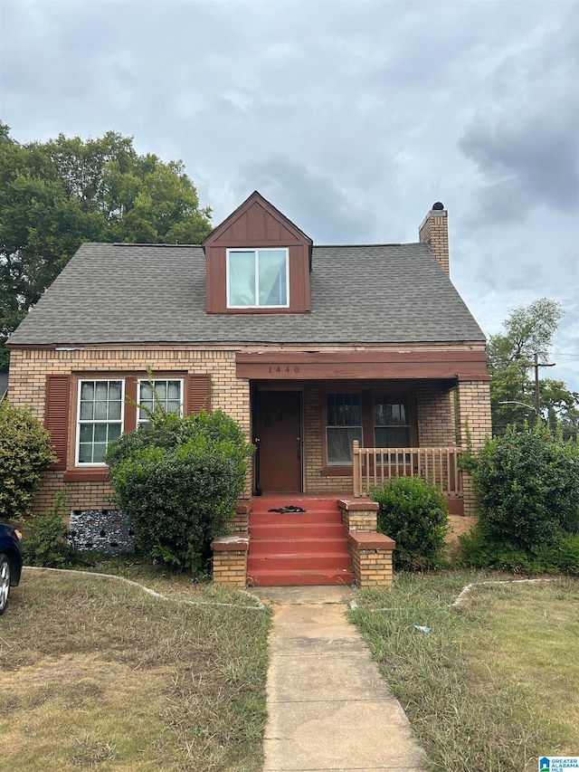 view of front of property featuring covered porch and a front lawn