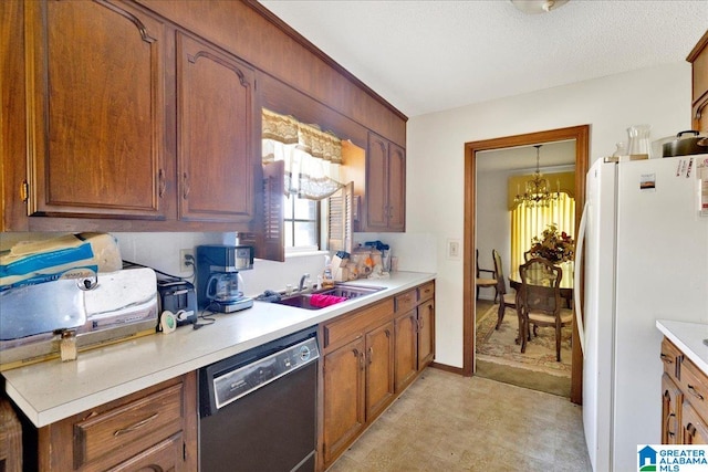 kitchen featuring sink, dishwasher, a textured ceiling, white fridge, and a notable chandelier