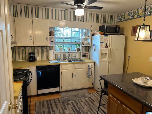 kitchen featuring white cabinetry, a textured ceiling, black appliances, and sink