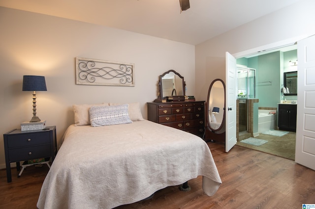 bedroom featuring connected bathroom, ceiling fan, and dark wood-type flooring