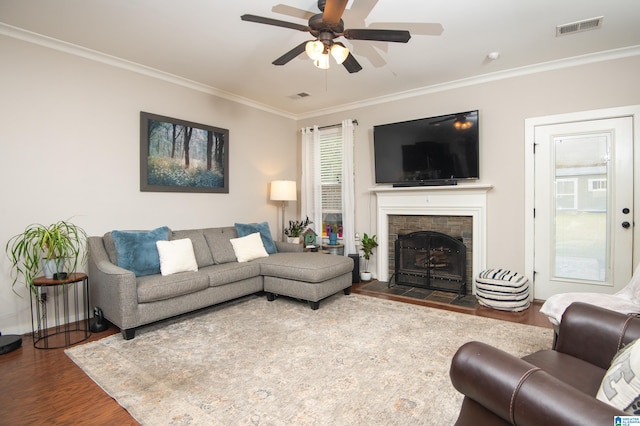 living room with dark wood-type flooring, ceiling fan, ornamental molding, and plenty of natural light