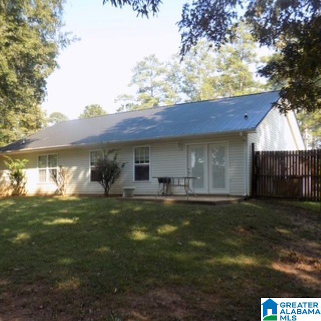 rear view of property featuring a lawn