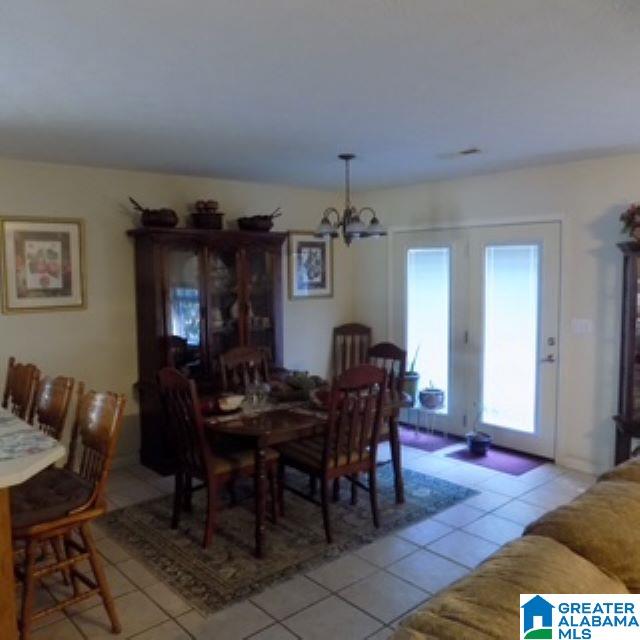 tiled dining room with a chandelier