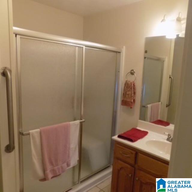 bathroom with vanity, tile patterned floors, and an enclosed shower