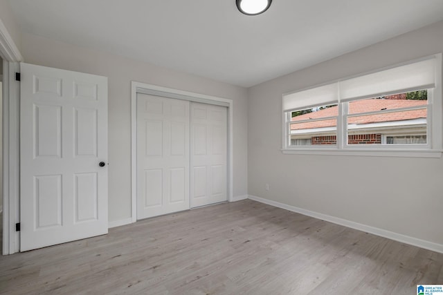 unfurnished bedroom featuring light hardwood / wood-style floors and a closet