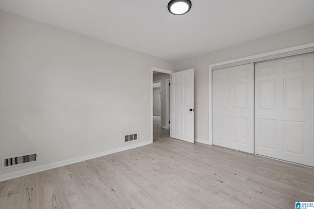 unfurnished bedroom featuring a closet and light wood-type flooring