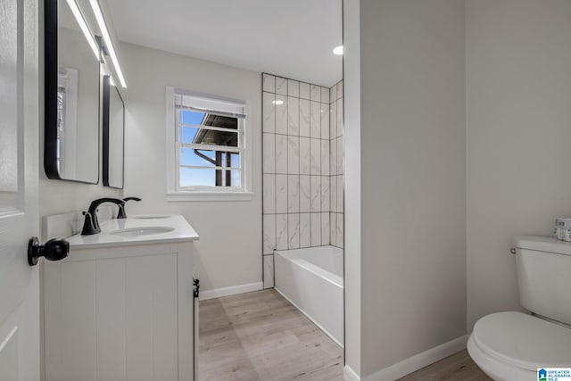2720 20th Pl, Ensley, Birmingham, AL 35208 - bathroom featuring toilet, wood finished floors, baseboards, vanity, and bathtub / shower combination