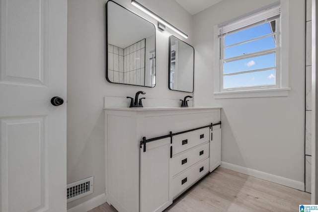 2720 20th Pl, Ensley, Birmingham, AL 35208 - bathroom featuring baseboards, wood finished floors, and double vanity