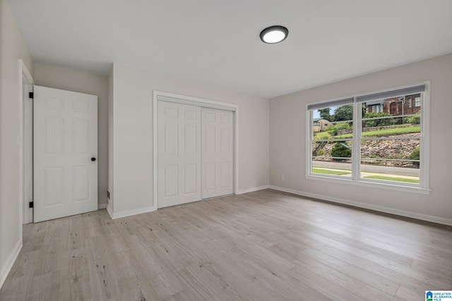 unfurnished bedroom featuring light hardwood / wood-style floors and a closet