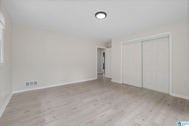 unfurnished bedroom with a closet and light hardwood / wood-style floors