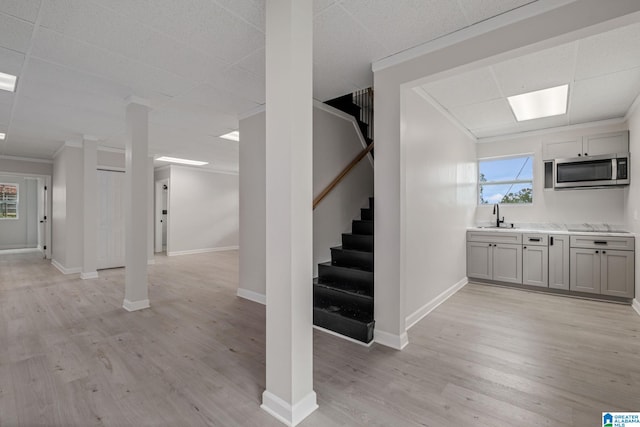 2720 20th Pl, Ensley, Birmingham, AL 35208 - below grade area featuring a sink, stairs, light wood-style flooring, baseboards, and a drop ceiling