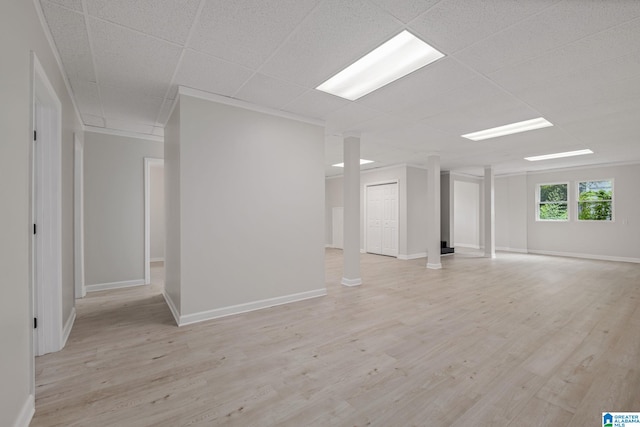 unfurnished room with a drop ceiling, ornamental molding, and light wood-type flooring