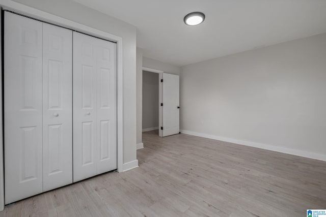 unfurnished bedroom with a closet and light hardwood / wood-style floors