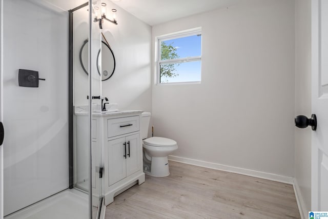 bathroom featuring vanity, a shower, hardwood / wood-style flooring, and toilet