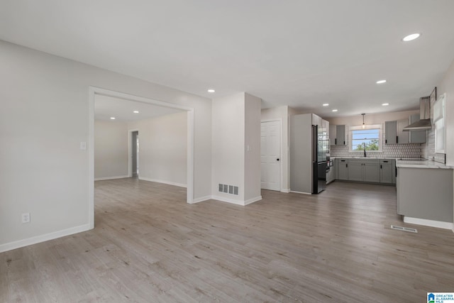 2720 20th Pl, Ensley, Birmingham, AL 35208 - unfurnished living room featuring light wood finished floors, recessed lighting, baseboards, and a sink