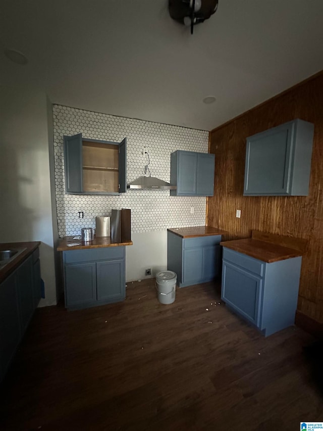 kitchen with wood walls, decorative backsplash, wood counters, and dark hardwood / wood-style flooring