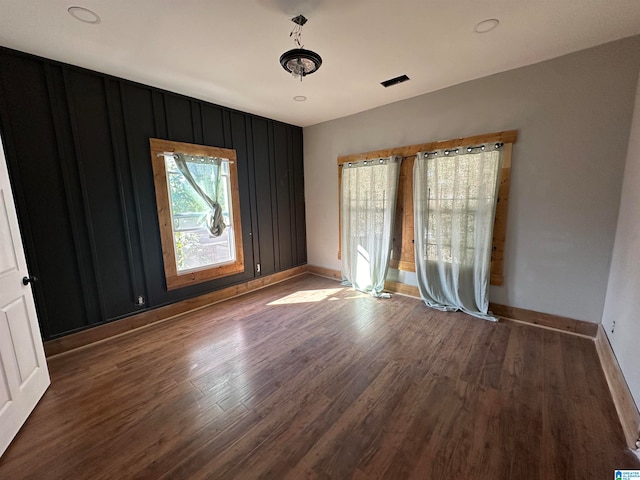 unfurnished room with dark wood-type flooring