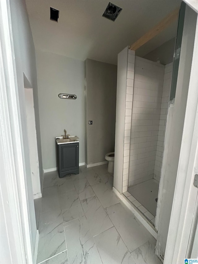 bathroom featuring toilet, sink, and tiled shower