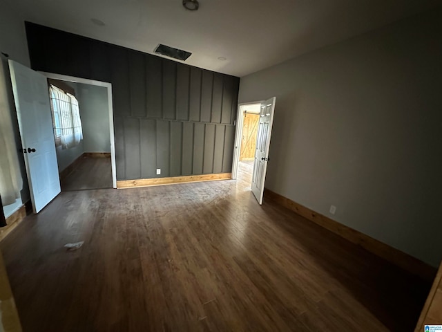 unfurnished room with dark hardwood / wood-style flooring