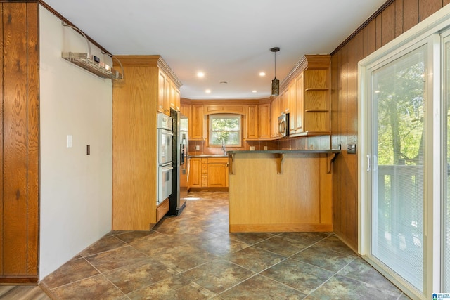 kitchen featuring kitchen peninsula, hanging light fixtures, white double oven, a breakfast bar area, and sink