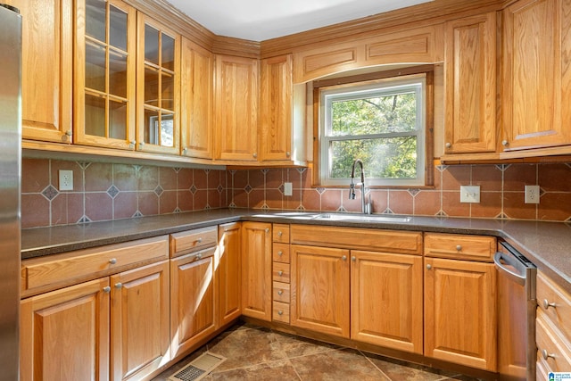 kitchen with tasteful backsplash, appliances with stainless steel finishes, and sink