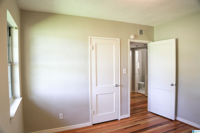 unfurnished bedroom with a textured ceiling and hardwood / wood-style flooring