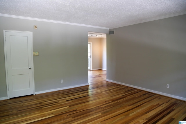 empty room featuring ornamental molding, dark hardwood / wood-style floors, and a textured ceiling