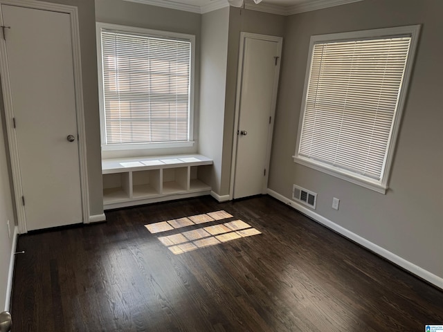 unfurnished bedroom featuring ornamental molding and dark wood-type flooring