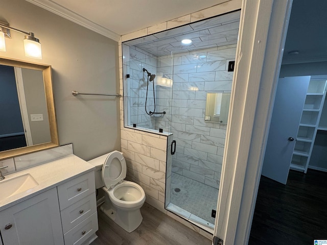 bathroom featuring a shower with door, wood-type flooring, toilet, vanity, and crown molding