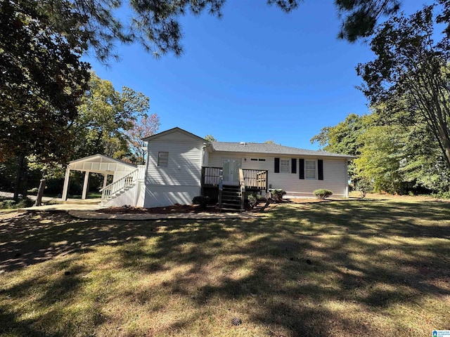 rear view of house with a deck and a lawn