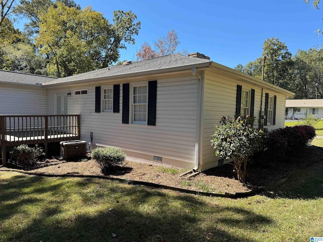 view of side of home with a wooden deck, a lawn, and central AC unit