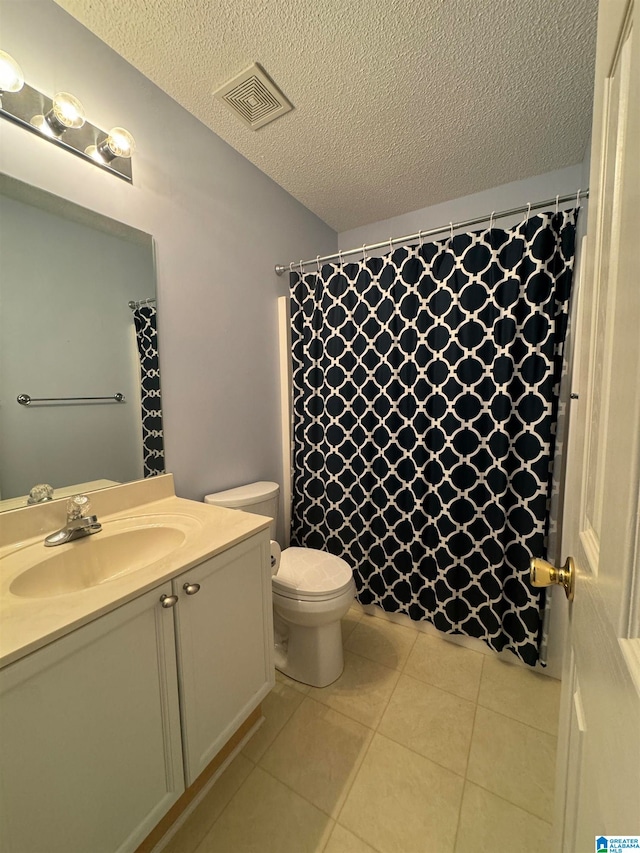 bathroom with vanity, a textured ceiling, and toilet