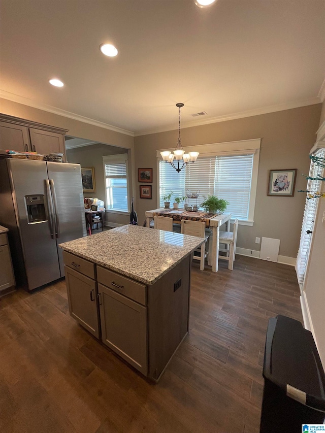 kitchen with a wealth of natural light, stainless steel fridge, crown molding, and dark wood-style flooring