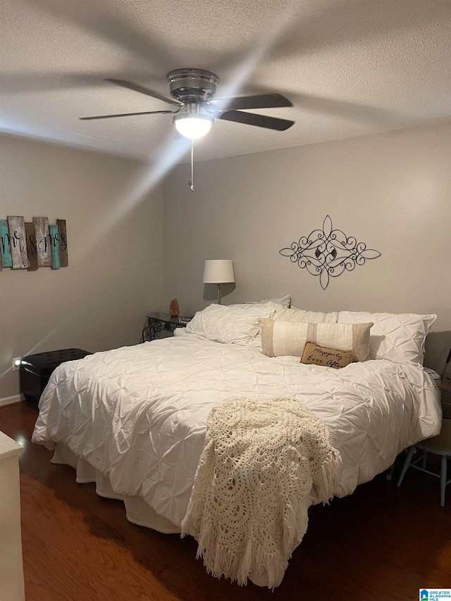 bedroom with ceiling fan, a textured ceiling, and wood finished floors