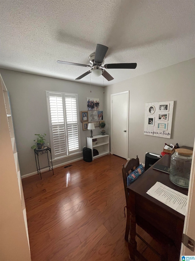 office with visible vents, ceiling fan, a textured ceiling, and wood finished floors