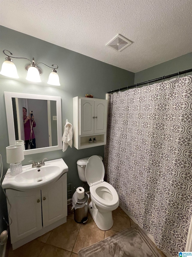 full bath featuring visible vents, toilet, a textured ceiling, vanity, and tile patterned floors