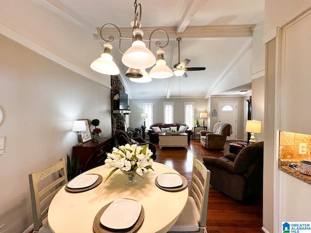 dining space with ceiling fan with notable chandelier, vaulted ceiling with beams, and wood finished floors