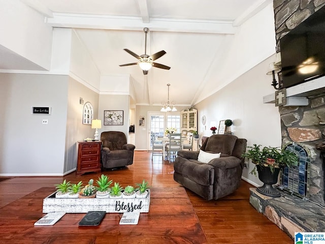 living area featuring a stone fireplace, ceiling fan with notable chandelier, wood finished floors, baseboards, and beam ceiling