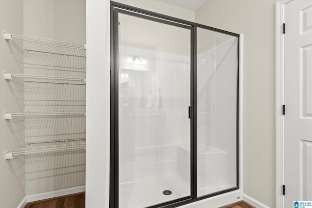 bathroom featuring a shower with door and hardwood / wood-style floors