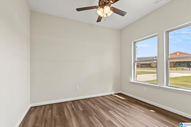 unfurnished room with hardwood / wood-style floors, a healthy amount of sunlight, and ceiling fan