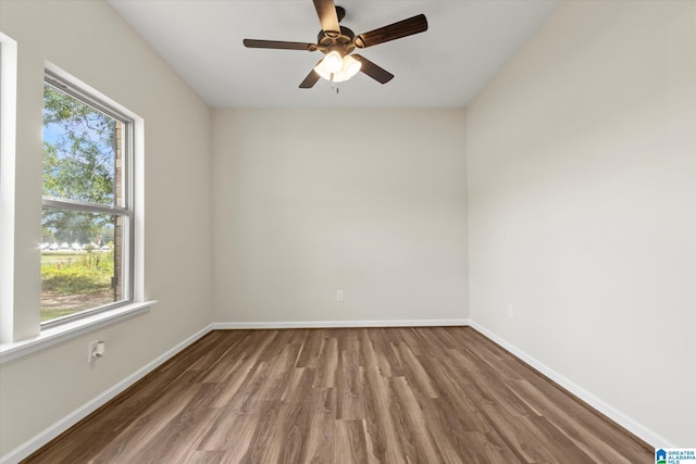 empty room with hardwood / wood-style floors, ceiling fan, and a wealth of natural light