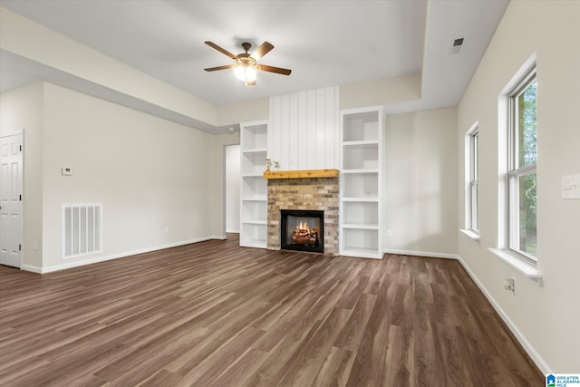 unfurnished living room featuring dark wood-type flooring, a fireplace, and ceiling fan